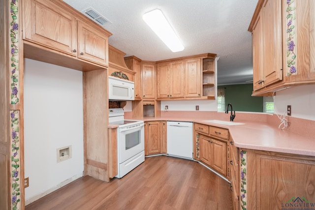 kitchen featuring a textured ceiling, sink, white appliances, and light wood-type flooring