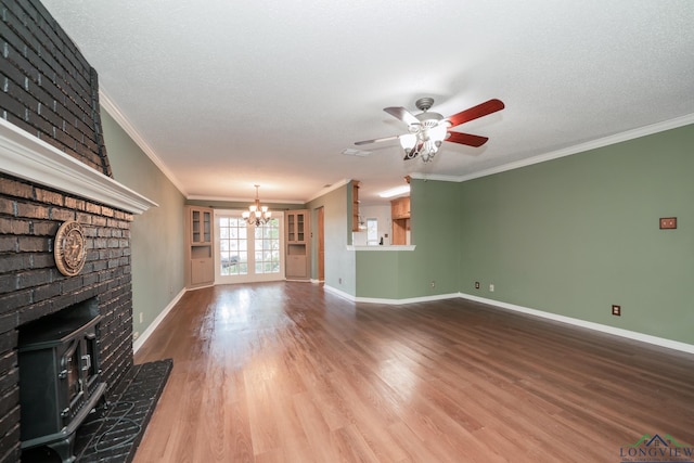 unfurnished living room featuring a textured ceiling, hardwood / wood-style flooring, a wood stove, and crown molding