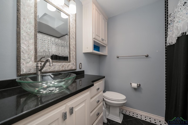 bathroom featuring toilet, vanity, and tile patterned floors