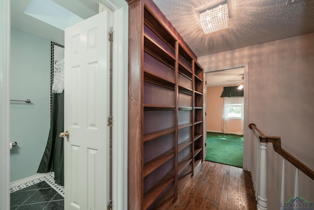 hall featuring dark hardwood / wood-style flooring and a textured ceiling