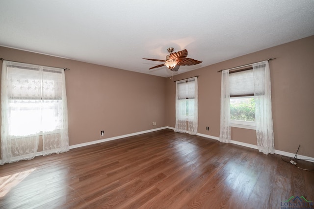 spare room with ceiling fan, dark wood-type flooring, and a textured ceiling