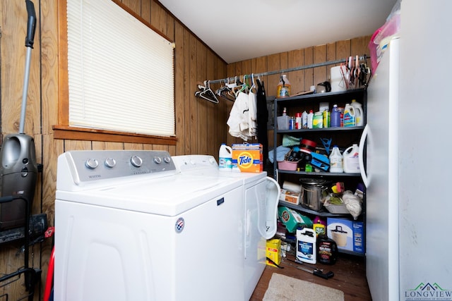 clothes washing area featuring wooden walls and washer and dryer