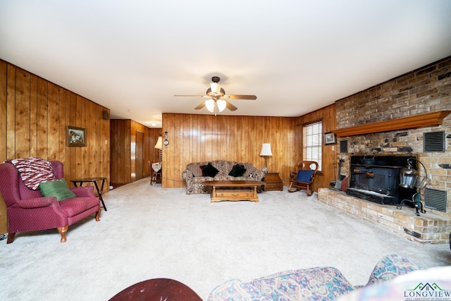 living room with carpet flooring, ceiling fan, and wood walls