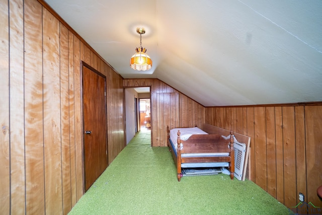 carpeted bedroom with lofted ceiling and wood walls