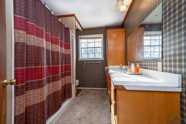 bathroom featuring a wealth of natural light, vanity, and ornamental molding