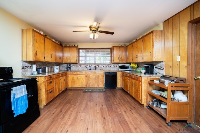 kitchen featuring light wood-type flooring, backsplash, ceiling fan, sink, and black appliances