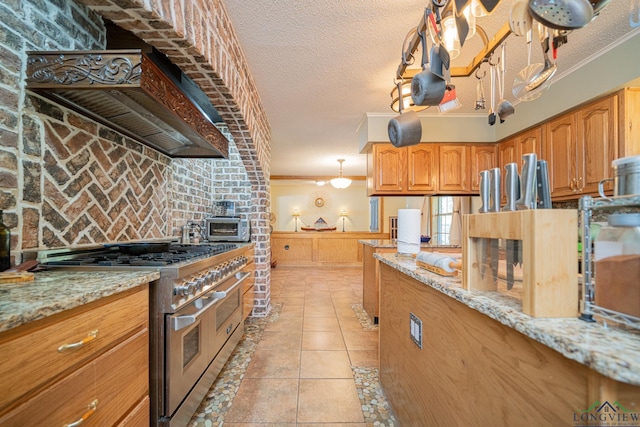 316 County Road 2750, Hughes Springs, TX 75656 - kitchen featuring range with two ovens, crown molding, decorative backsplash, light stone counters, and light tile patterned flooring