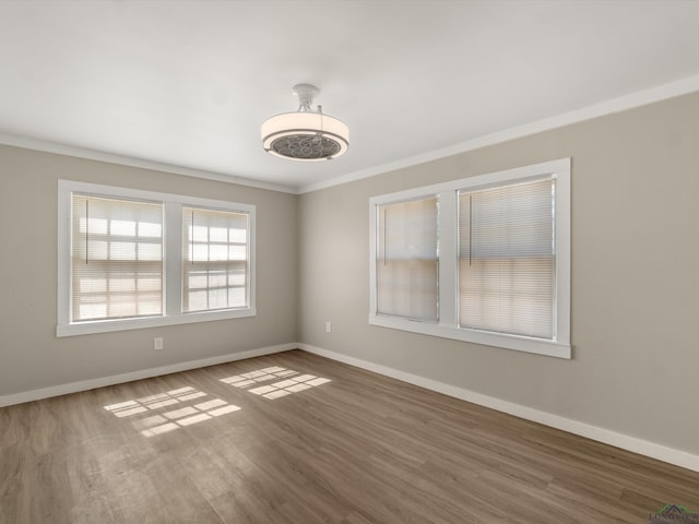 spare room featuring hardwood / wood-style floors and crown molding