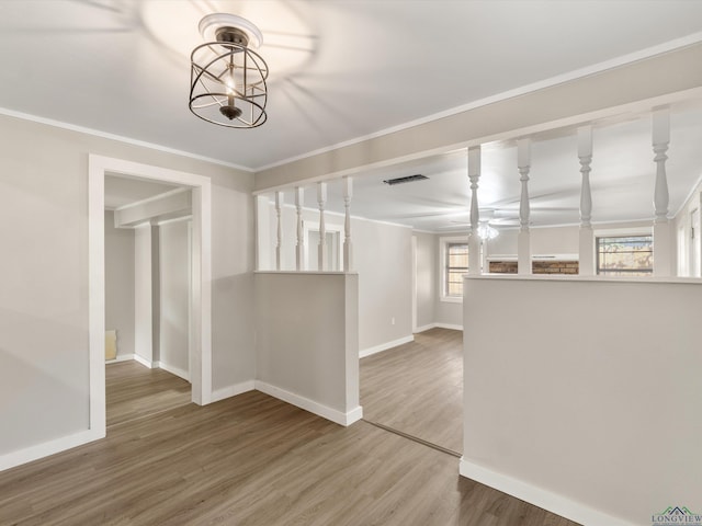 interior space featuring ceiling fan, wood-type flooring, and crown molding