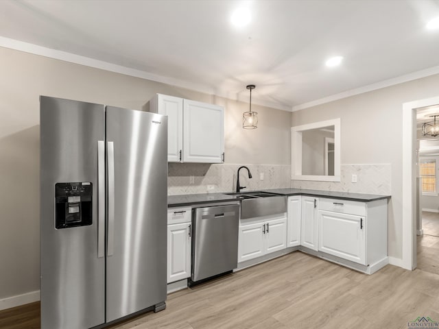 kitchen with white cabinetry, stainless steel appliances, decorative light fixtures, and light hardwood / wood-style floors