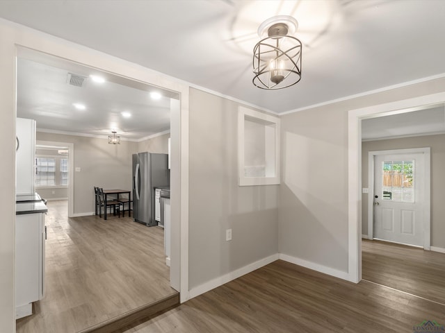 hall with hardwood / wood-style floors and ornamental molding