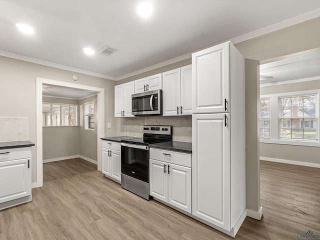 kitchen featuring backsplash, white cabinets, stainless steel appliances, and light wood-type flooring