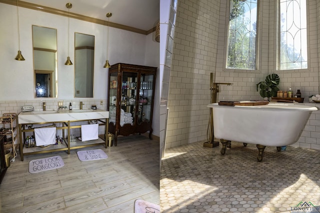 bathroom with a bath, vanity, tile walls, and crown molding