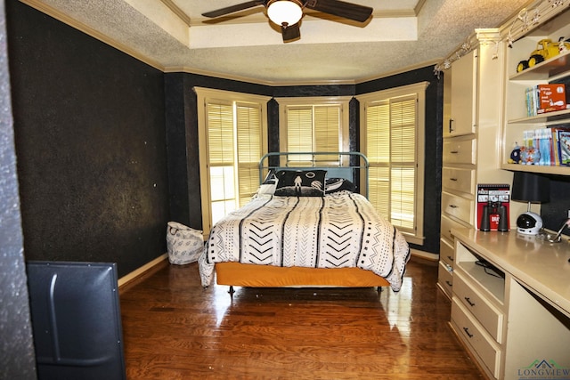 bedroom featuring ornamental molding, dark hardwood / wood-style floors, ceiling fan, and a tray ceiling