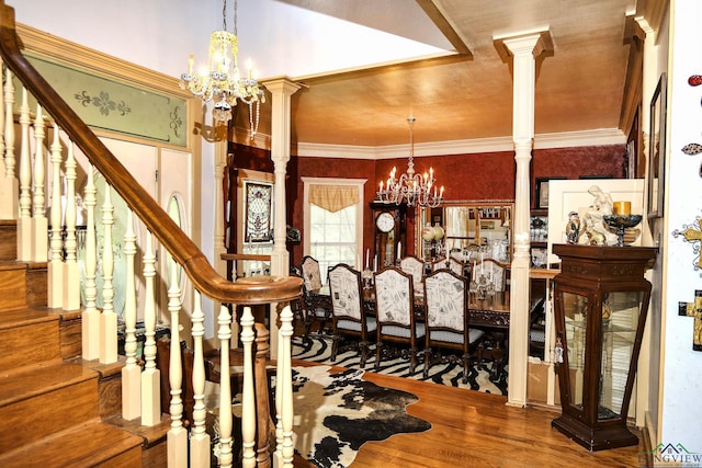 dining area featuring wood-type flooring, decorative columns, and a notable chandelier