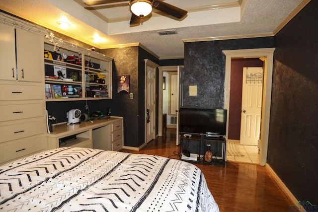 bedroom featuring a textured ceiling, a raised ceiling, ceiling fan, crown molding, and dark hardwood / wood-style floors