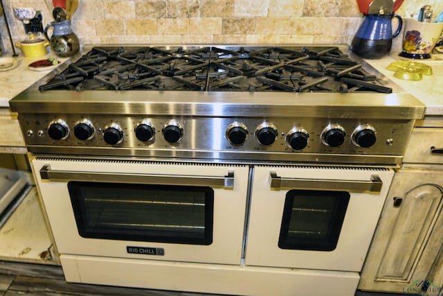 details with decorative backsplash and range with two ovens