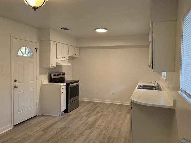 kitchen with white cabinets, electric range, light hardwood / wood-style flooring, and sink