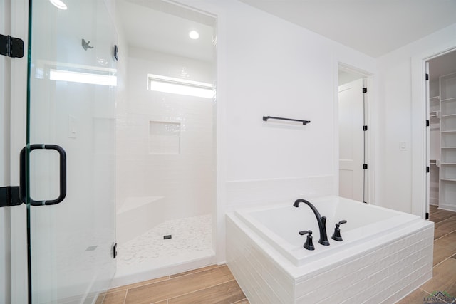 bathroom featuring shower with separate bathtub