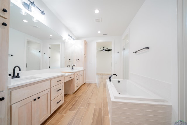 bathroom featuring vanity, ceiling fan, and plus walk in shower