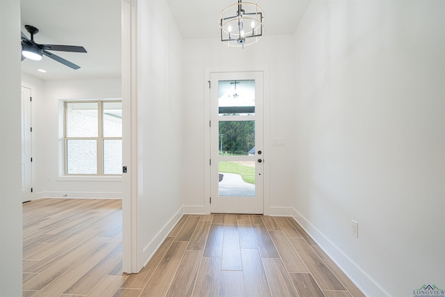 foyer entrance featuring light hardwood / wood-style flooring and ceiling fan with notable chandelier