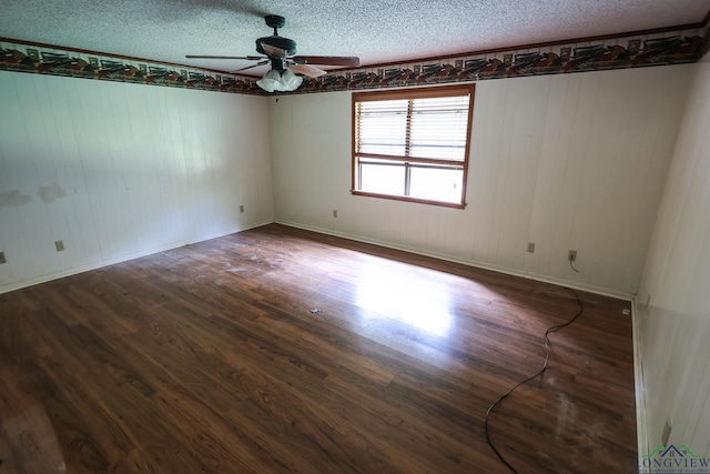 empty room with ceiling fan, dark hardwood / wood-style flooring, and a textured ceiling