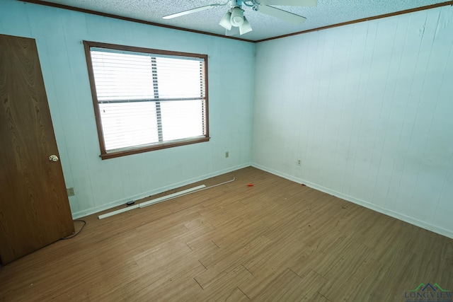 empty room featuring a textured ceiling, light hardwood / wood-style flooring, ceiling fan, and crown molding