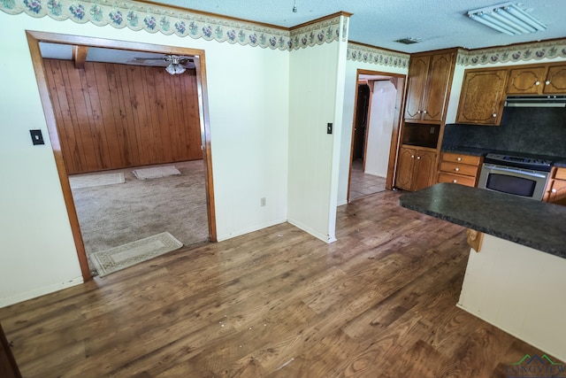 kitchen featuring ceiling fan, dark hardwood / wood-style floors, ventilation hood, a textured ceiling, and electric stove