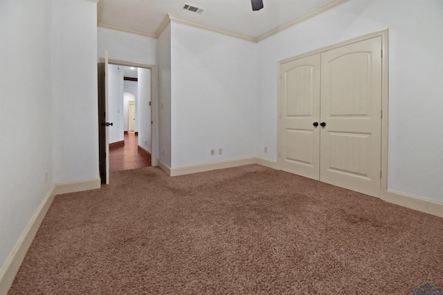 unfurnished bedroom featuring ceiling fan, a closet, carpet floors, and ornamental molding