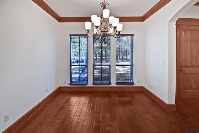 unfurnished dining area featuring a chandelier, dark hardwood / wood-style floors, and ornamental molding