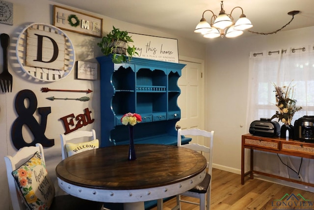 dining area with hardwood / wood-style flooring and a notable chandelier