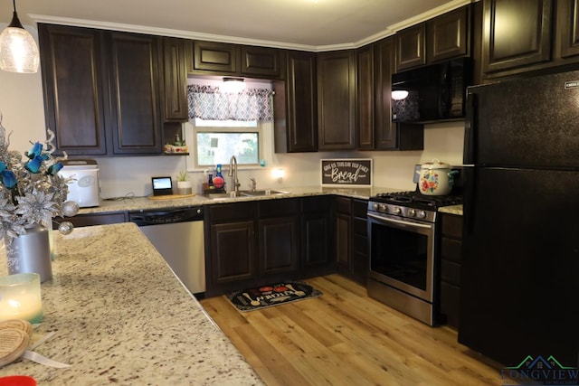 kitchen with black appliances, sink, decorative light fixtures, light hardwood / wood-style floors, and dark brown cabinets