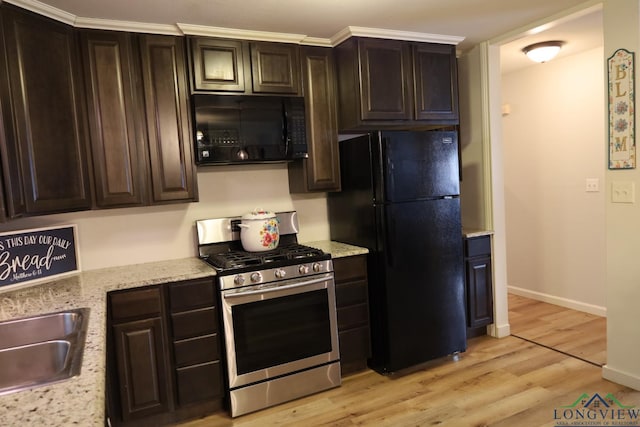 kitchen with black appliances, sink, light stone countertops, light wood-type flooring, and dark brown cabinets