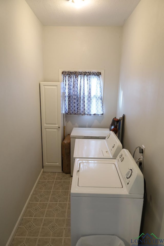 laundry room with washer and clothes dryer, a textured ceiling, and tile patterned flooring