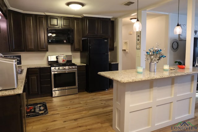 kitchen with light stone countertops, light wood-type flooring, dark brown cabinets, black appliances, and hanging light fixtures