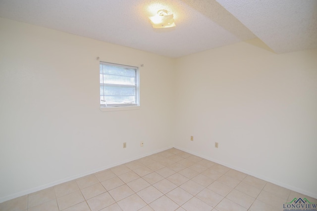 tiled spare room with a textured ceiling