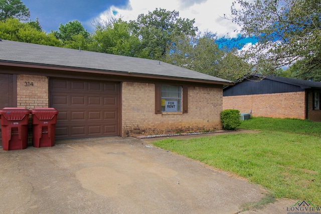 view of front of home with a front yard, a garage, and central AC unit