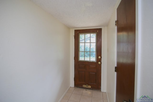 entryway with light tile patterned floors and a textured ceiling