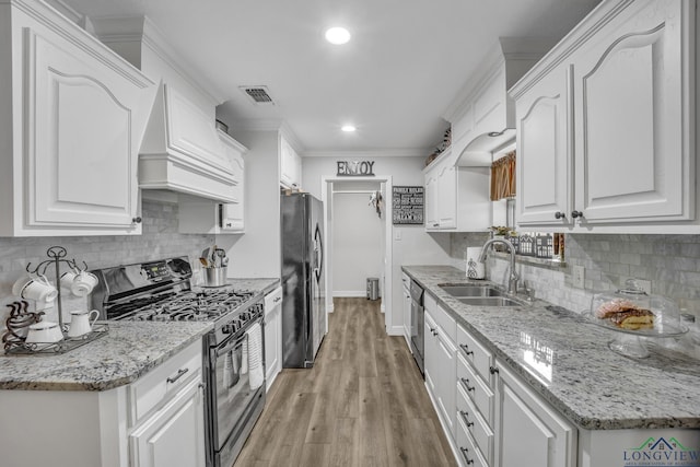 kitchen featuring white cabinetry, black refrigerator, sink, and range with gas stovetop