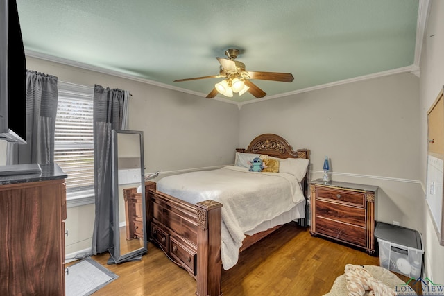 bedroom featuring crown molding, light hardwood / wood-style flooring, and ceiling fan