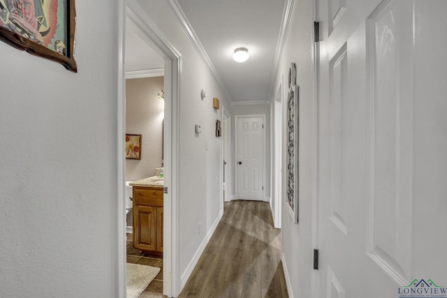 corridor with ornamental molding and light hardwood / wood-style flooring