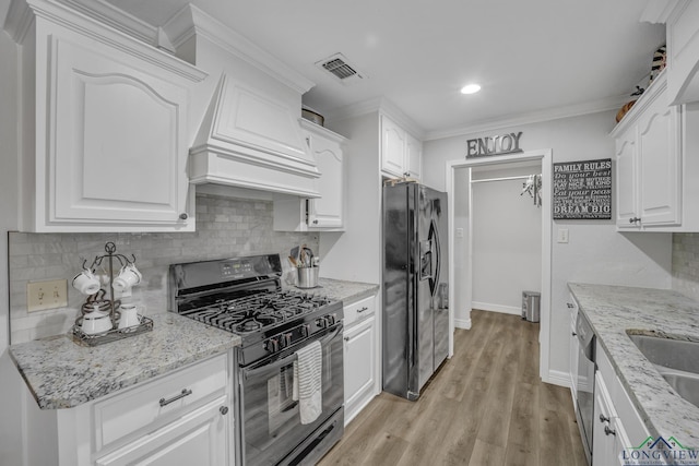 kitchen with premium range hood, white cabinets, light stone countertops, and black appliances