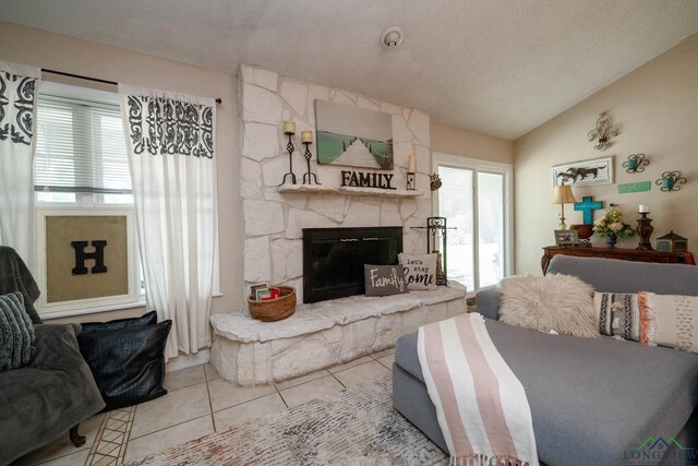 3365 Omie Dr, Longview, TX 75605 - living area featuring tile patterned flooring, lofted ceiling, a fireplace, and a textured ceiling