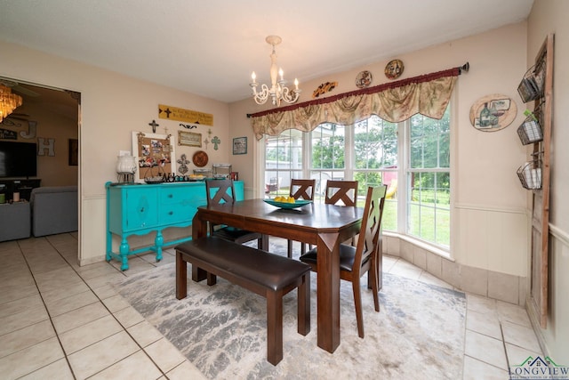 3365 Omie Dr, Longview, TX 75605 - dining area with light tile patterned floors, a chandelier, and a wainscoted wall