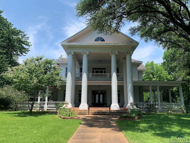 view of front of house with a balcony, a porch, and a front yard