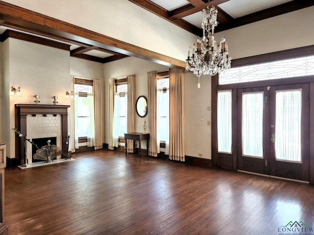 unfurnished living room with french doors, dark hardwood / wood-style flooring, coffered ceiling, beam ceiling, and an inviting chandelier