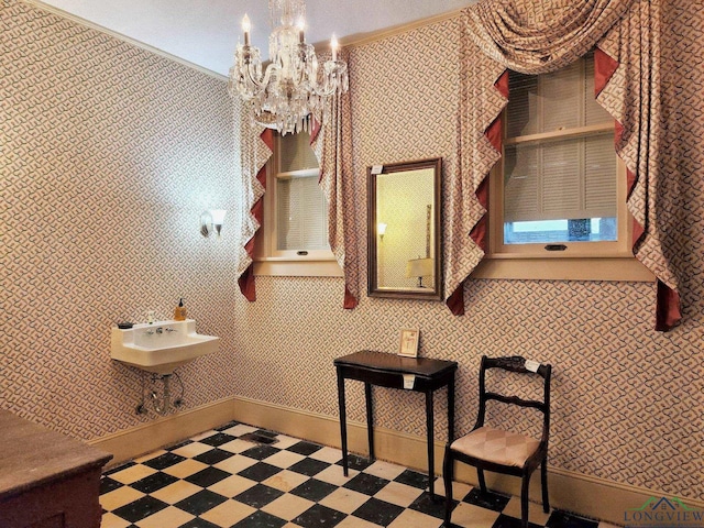 bathroom featuring a chandelier, crown molding, and sink