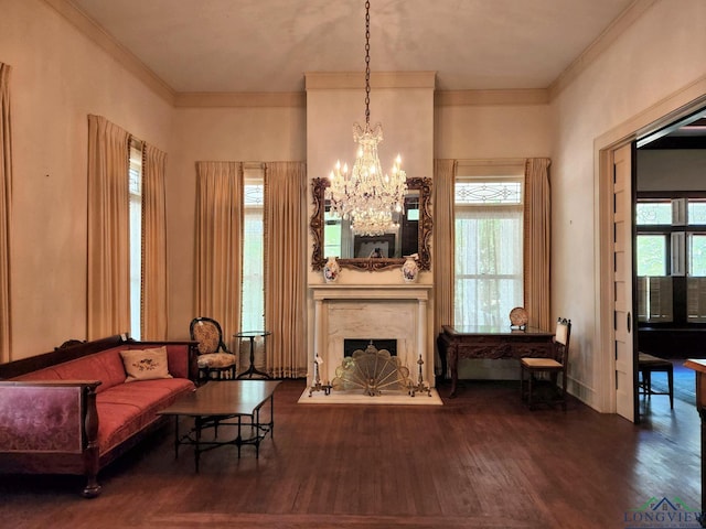 sitting room with a notable chandelier, wood-type flooring, a premium fireplace, and crown molding