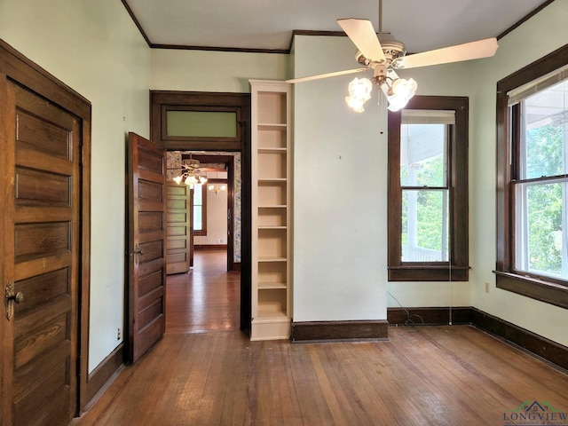 unfurnished room with ceiling fan, dark hardwood / wood-style floors, and crown molding