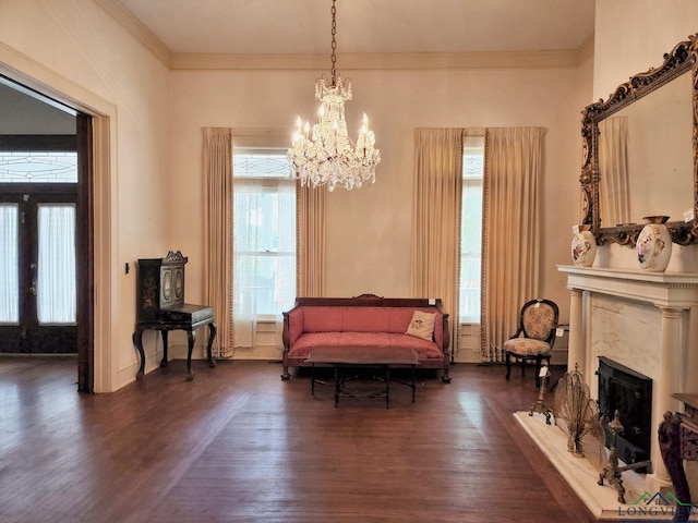 sitting room with crown molding, dark wood-type flooring, a high end fireplace, and a chandelier